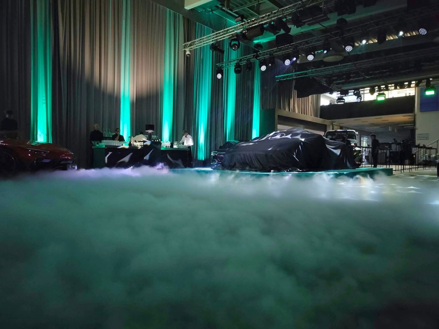 Zakrytý vůz v nasvíceném showroomu s mlhou