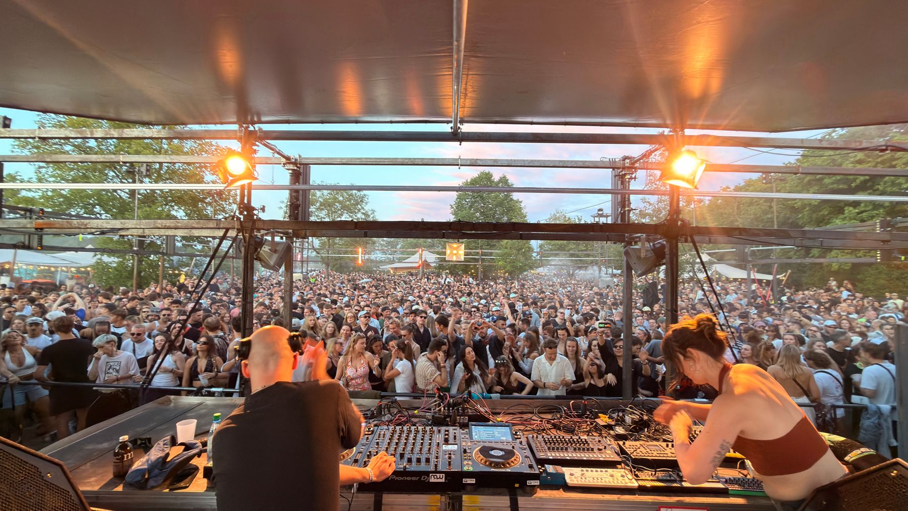 Pohled z DJ pultu na dav při západu slunce